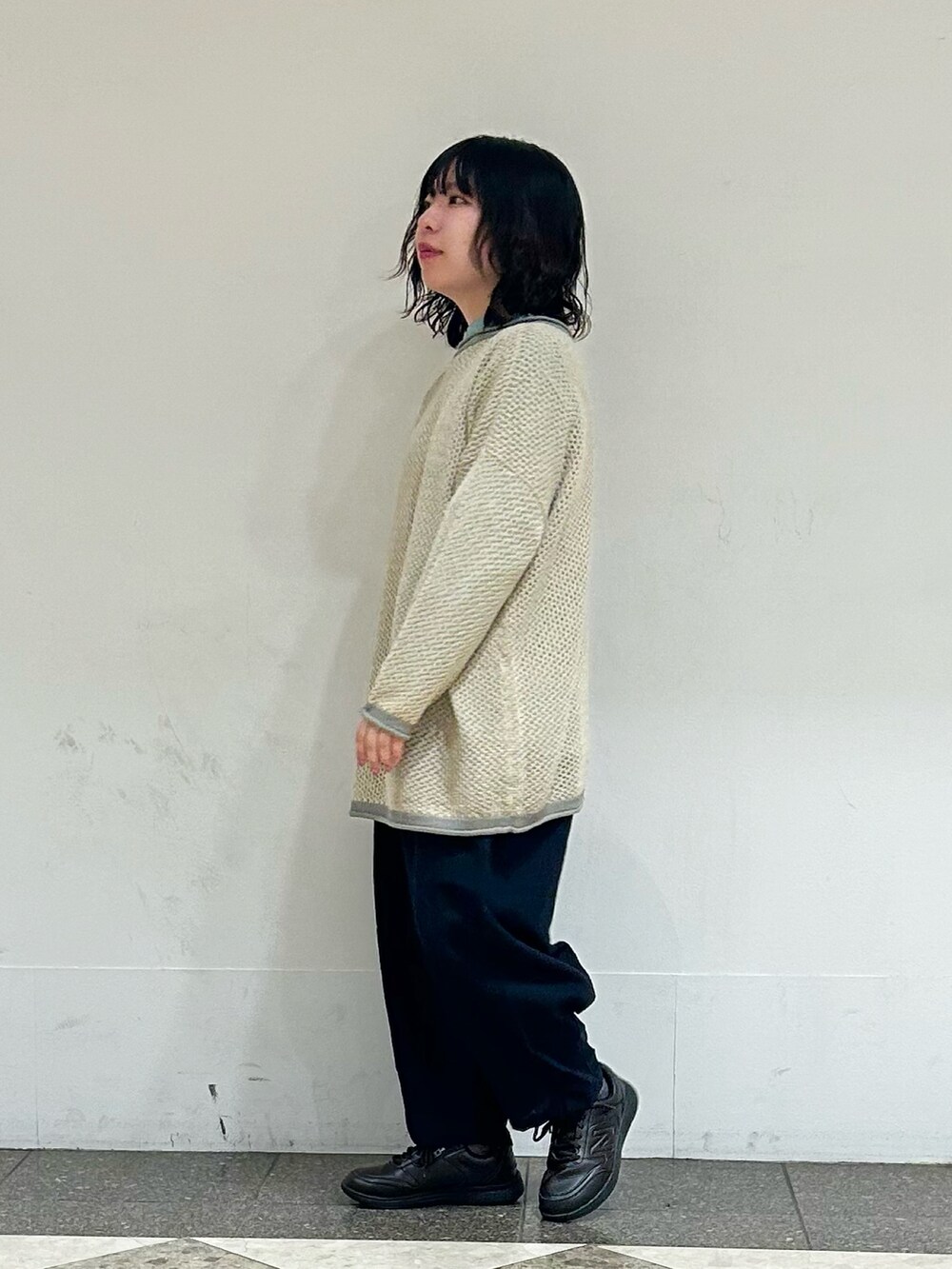 グリーン系のシャツ/ブラウス、ベージュ系のニット/セーター、グレー系のその他パンツを着用したレディースの春コーディネートの2枚目の写真