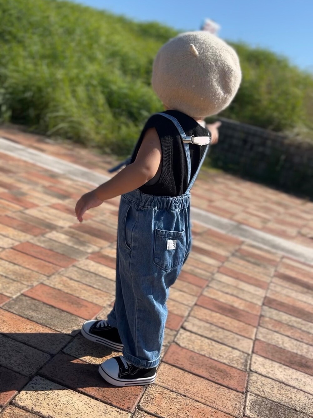 ブルー系のサロペット/オーバーオール、ブラック系のスニーカーを着用したキッズの秋コーディネートの2枚目の写真