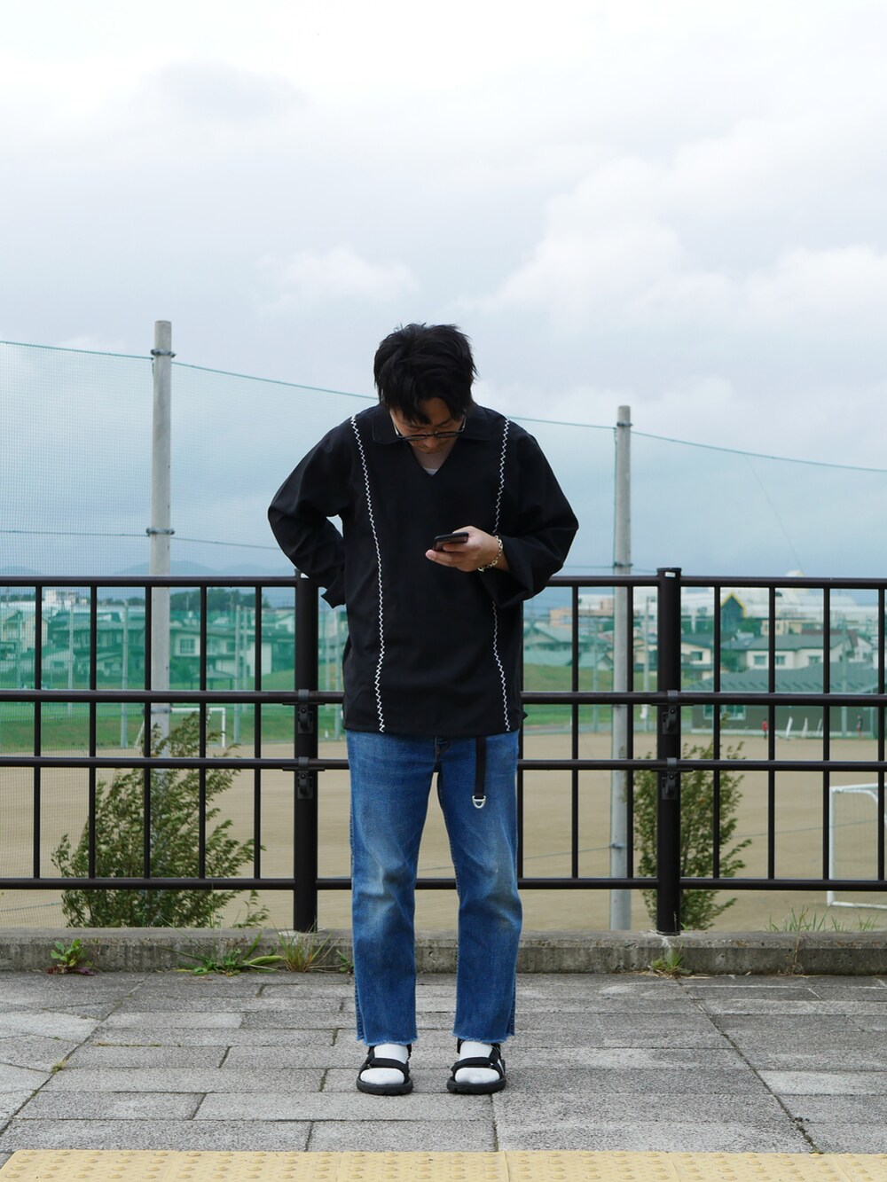 ブルー系のデニムパンツ、ブラック系のサンダル、ブラック系のシャツ/ブラウスを着用したメンズの秋コーディネートの2枚目の写真