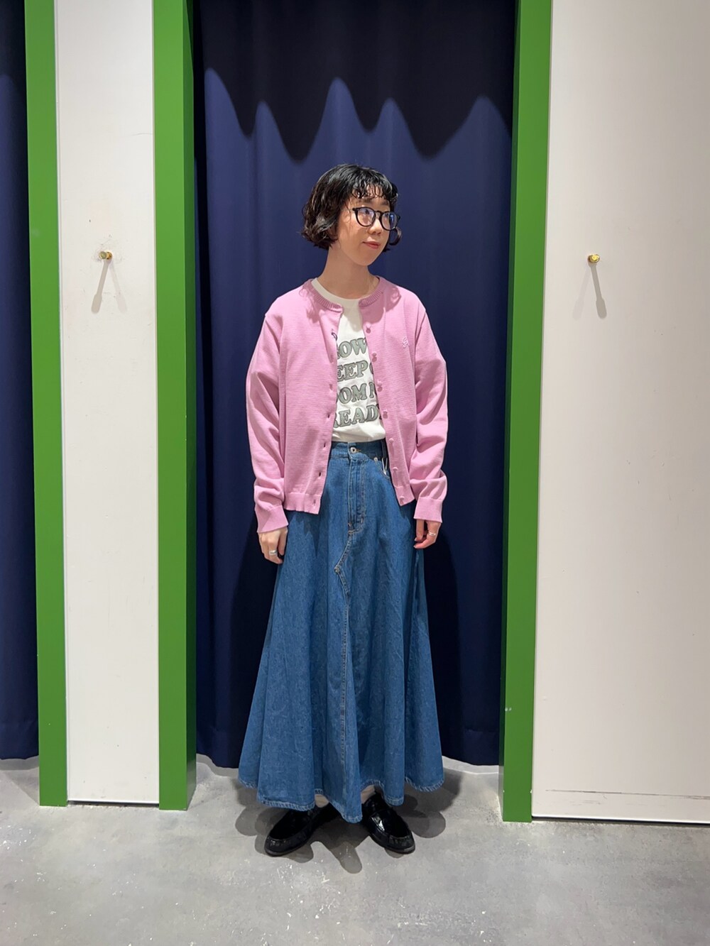 ホワイト系のTシャツ/カットソー、ピンク系のカーディガン/ボレロ、ブルー系のスカートを着用したレディースの春コーディネートの2枚目の写真