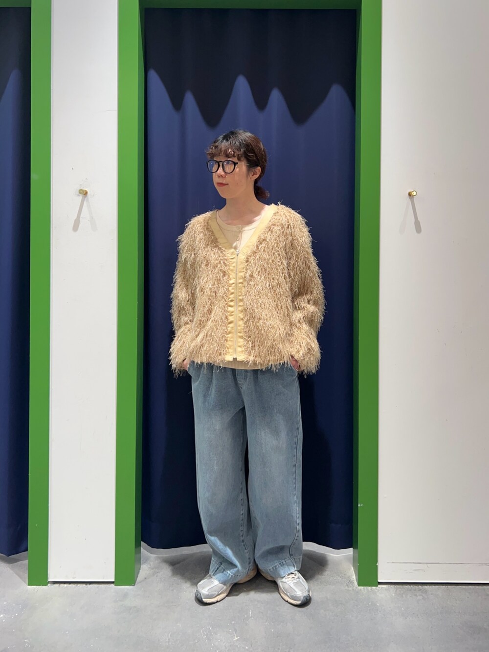 ベージュ系のブルゾン、ホワイト系のニット/セーター、ブルー系のデニムパンツを着用したレディースの冬コーディネートの2枚目の写真