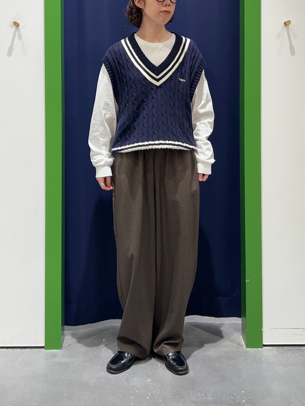 ブルー系のベスト、グレー系のその他パンツを着用したレディースの秋コーディネートの2枚目の写真