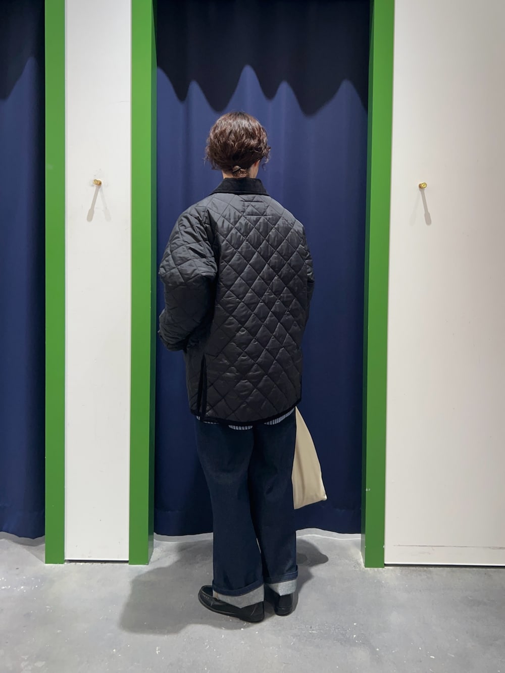 ブルー系のシャツ/ブラウス、ブラック系のブルゾン、ブルー系のデニムパンツを着用したレディースの冬コーディネートの2枚目の写真