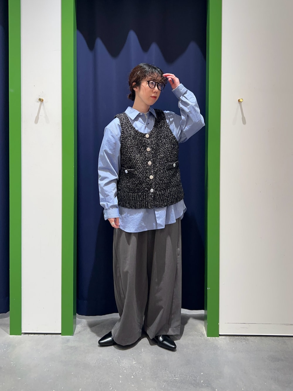 ブラック系のベスト、グレー系のデニムパンツ、ブルー系のシャツ/ブラウスを着用したレディースの冬コーディネートの2枚目の写真