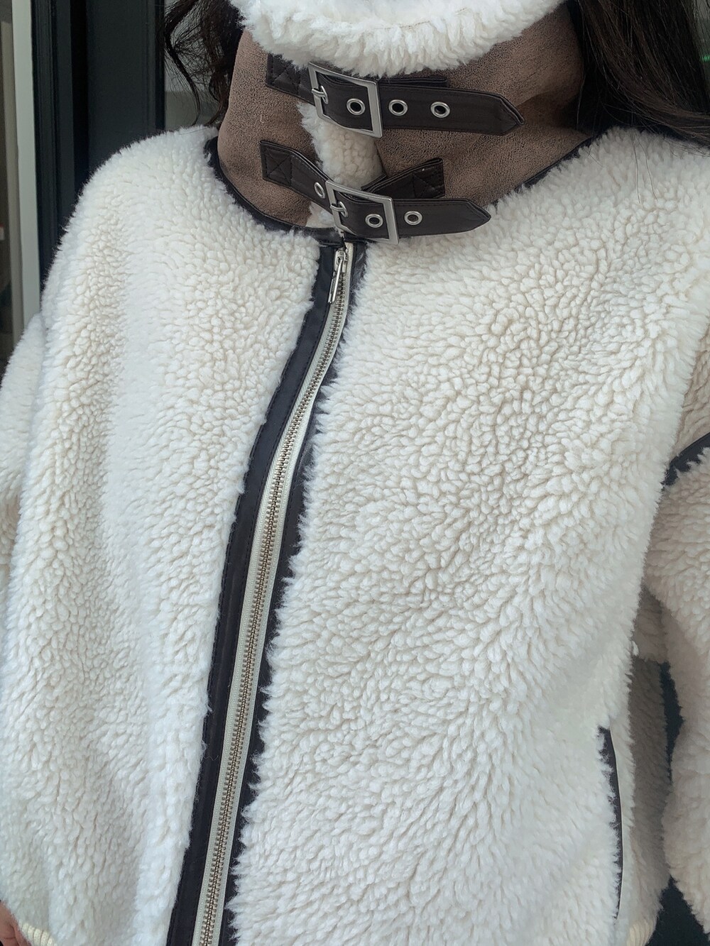 ブルー系のデニムパンツ、ブラック系のブーツ、ホワイト系のバックパック/リュックを着用したレディースの冬コーディネートの7枚目の写真