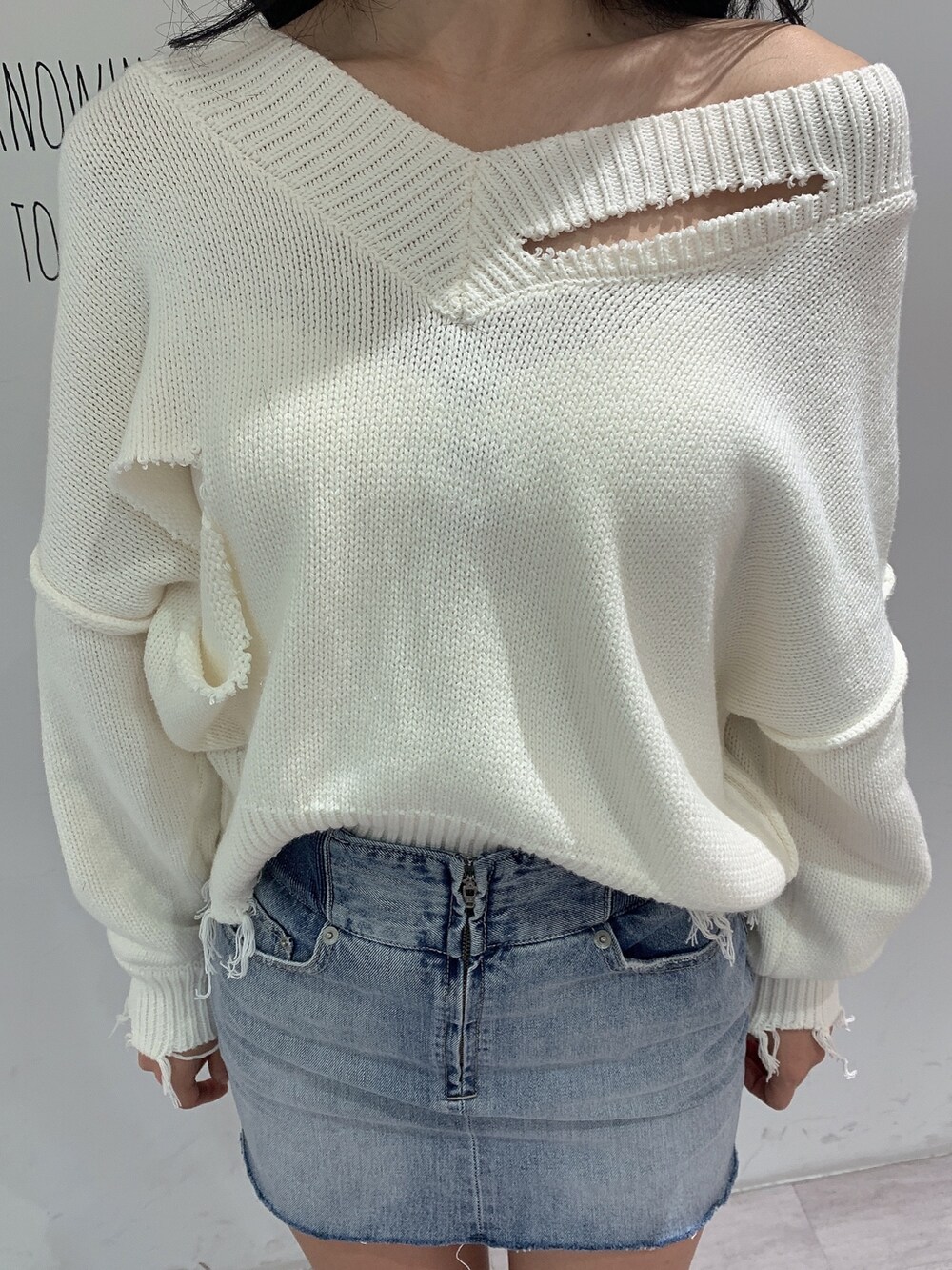 ブルー系のスカート、ブラック系のブーツ、ホワイト系のニット/セーターを着用したレディースの冬コーディネートの7枚目の写真