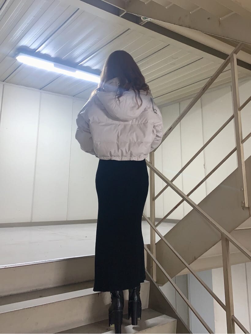 ブラック系のブーツ、ブラック系のニット/セーター、ブラック系のスカートを着用したレディースの秋コーディネートの2枚目の写真