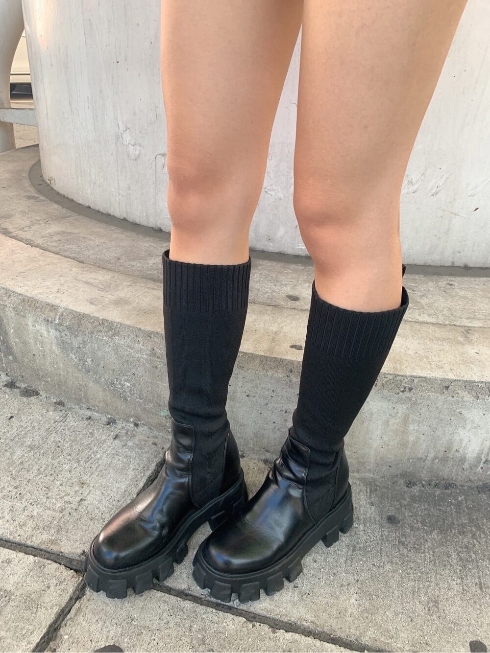 ピンク系のニット/セーター、ブラック系のスカート、ブラック系のブーツを着用したレディースの秋コーディネートの7枚目の写真