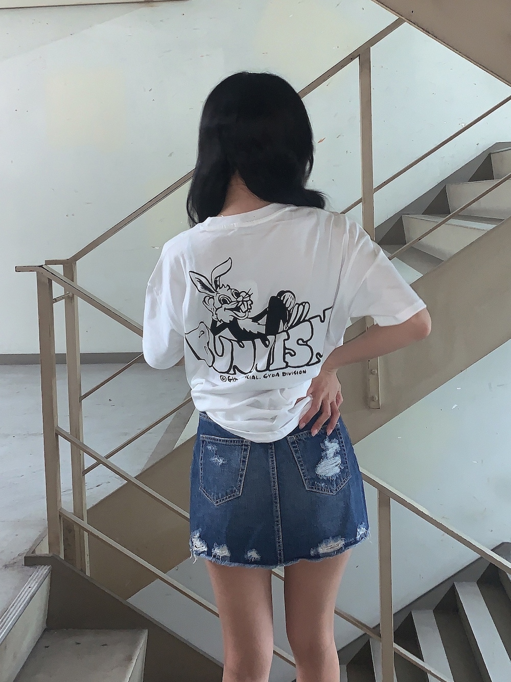 ブルー系のデニムスカート、ホワイト系のサンダル、ホワイト系のTシャツ/カットソーを着用したレディースの春コーディネートの5枚目の写真