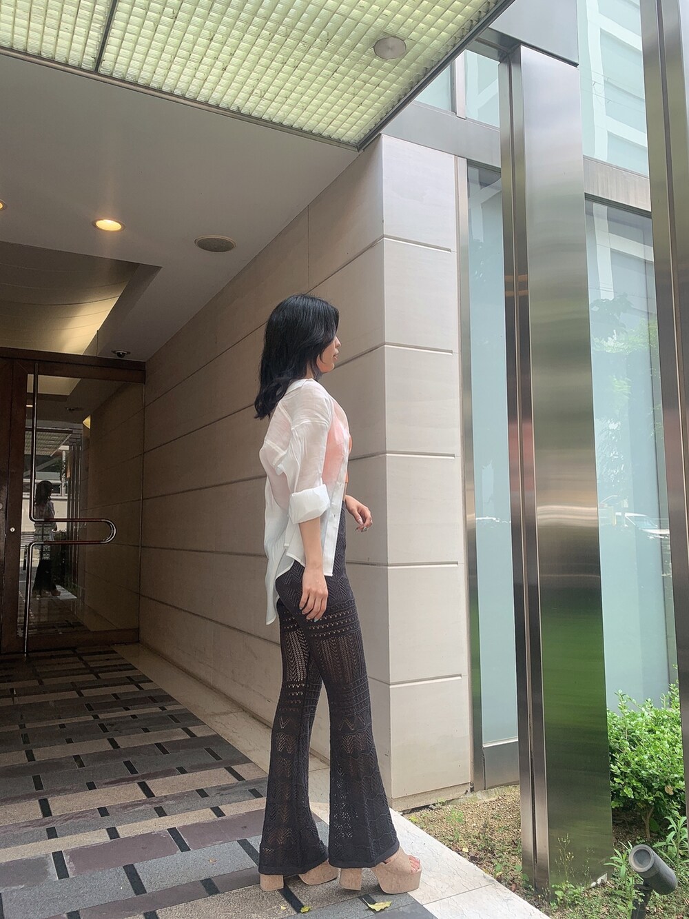 ホワイト系のサンダル、グレー系のその他パンツ、オレンジ系のニット/セーターを着用したレディースの春コーディネートの3枚目の写真