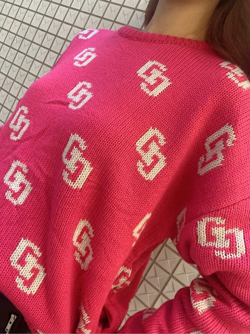 ピンク系のニット/セーター、ブラック系のスカート、ブラック系のブーツを着用したレディースの秋コーディネートの5枚目の写真