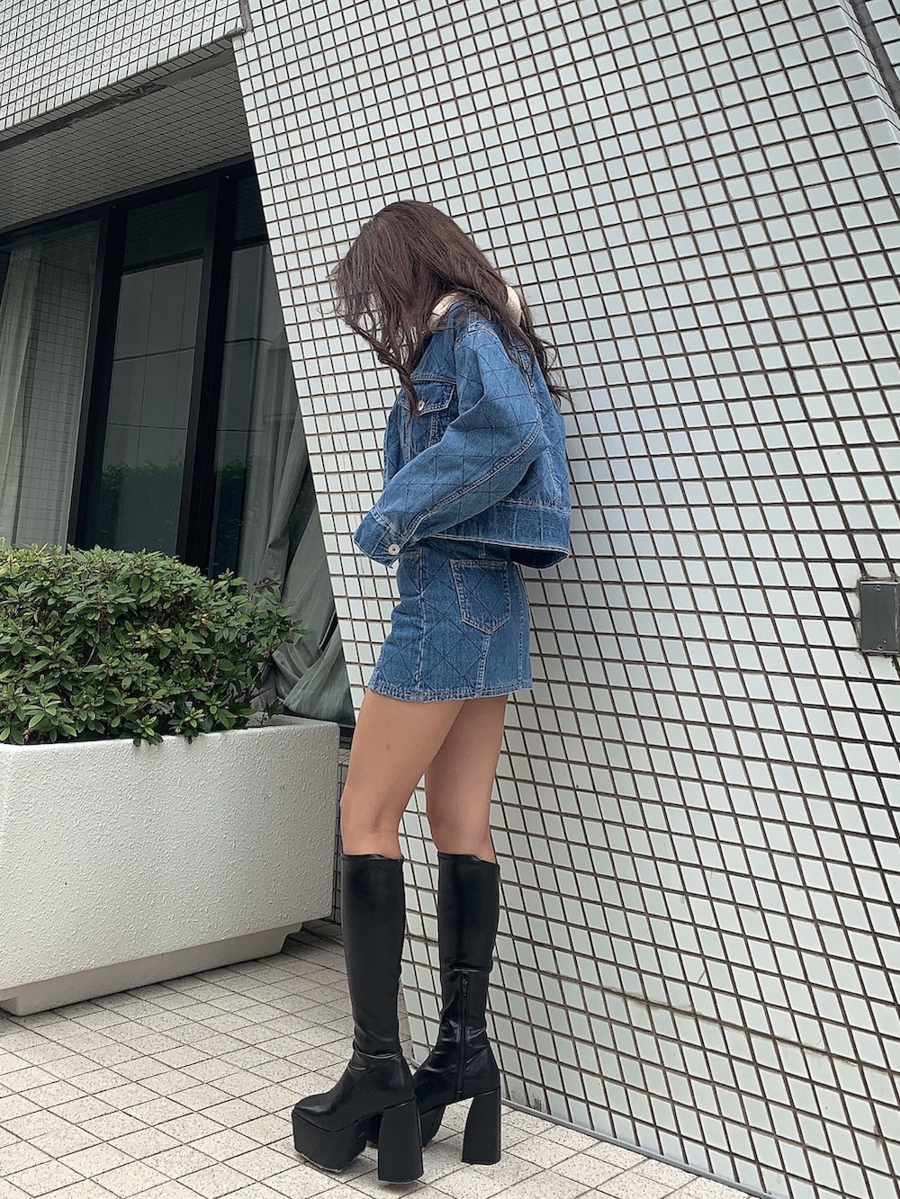 ブラック系のブーツ、ブルー系のデニムスカート、ブルー系のジャケット/アウターを着用したレディースの秋コーディネートの2枚目の写真