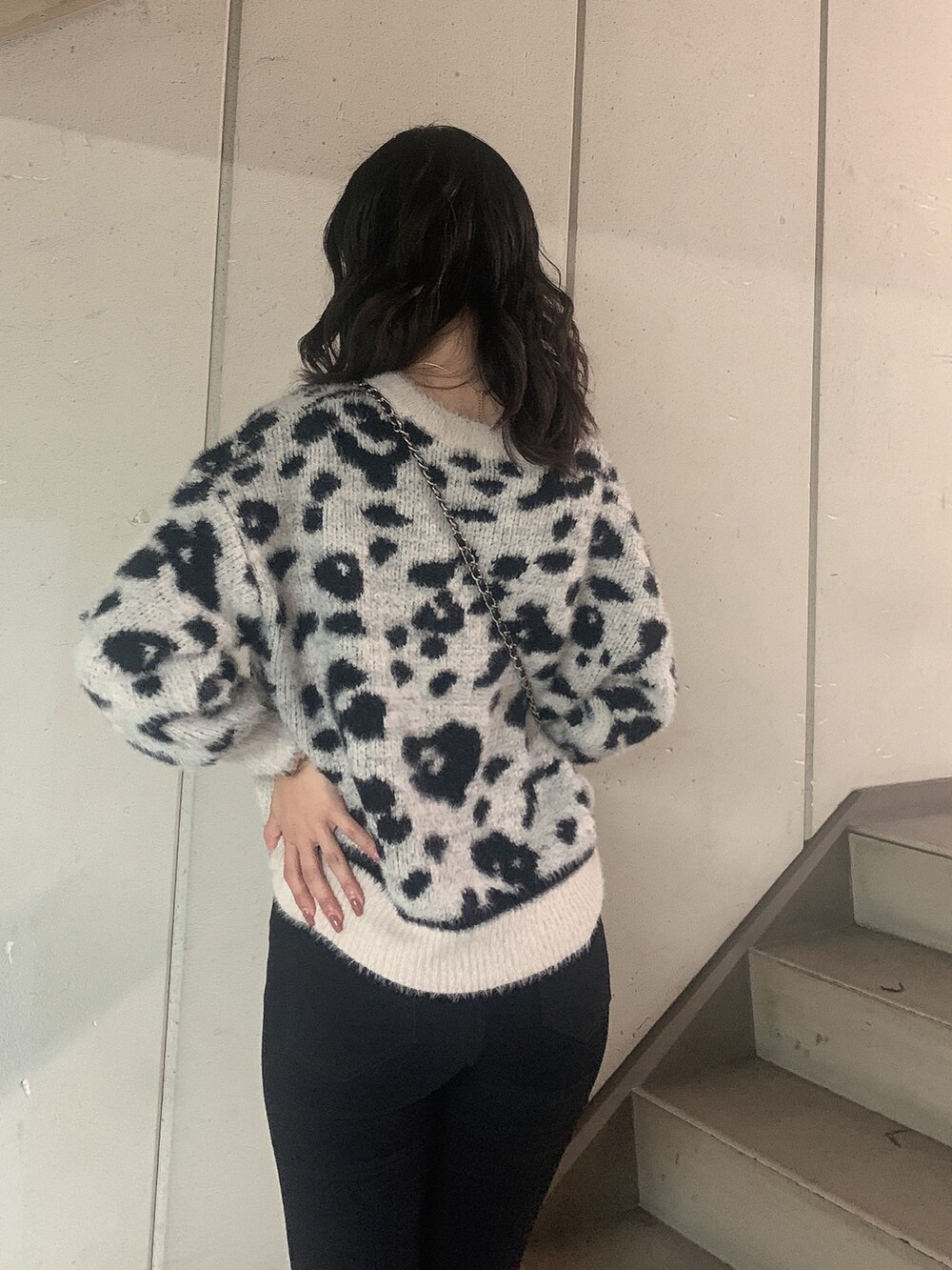 ブラック系のブーツ、ブラック系のデニムパンツ、ホワイト系のニット/セーターを着用したレディースの冬コーディネートの6枚目の写真