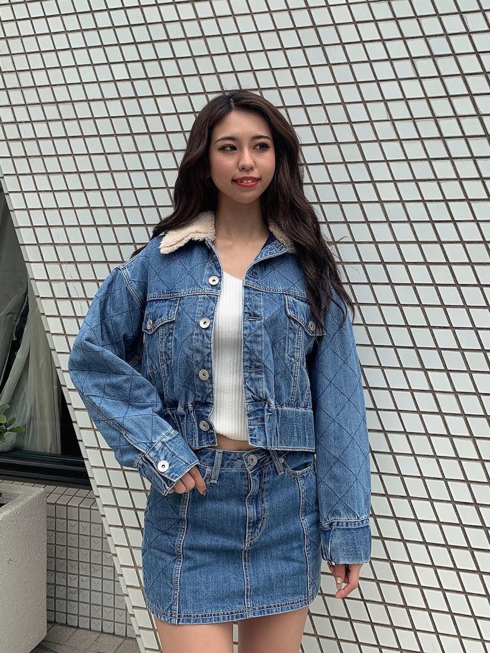 ブラック系のブーツ、ブルー系のデニムスカート、ブルー系のジャケット/アウターを着用したレディースの秋コーディネートの4枚目の写真