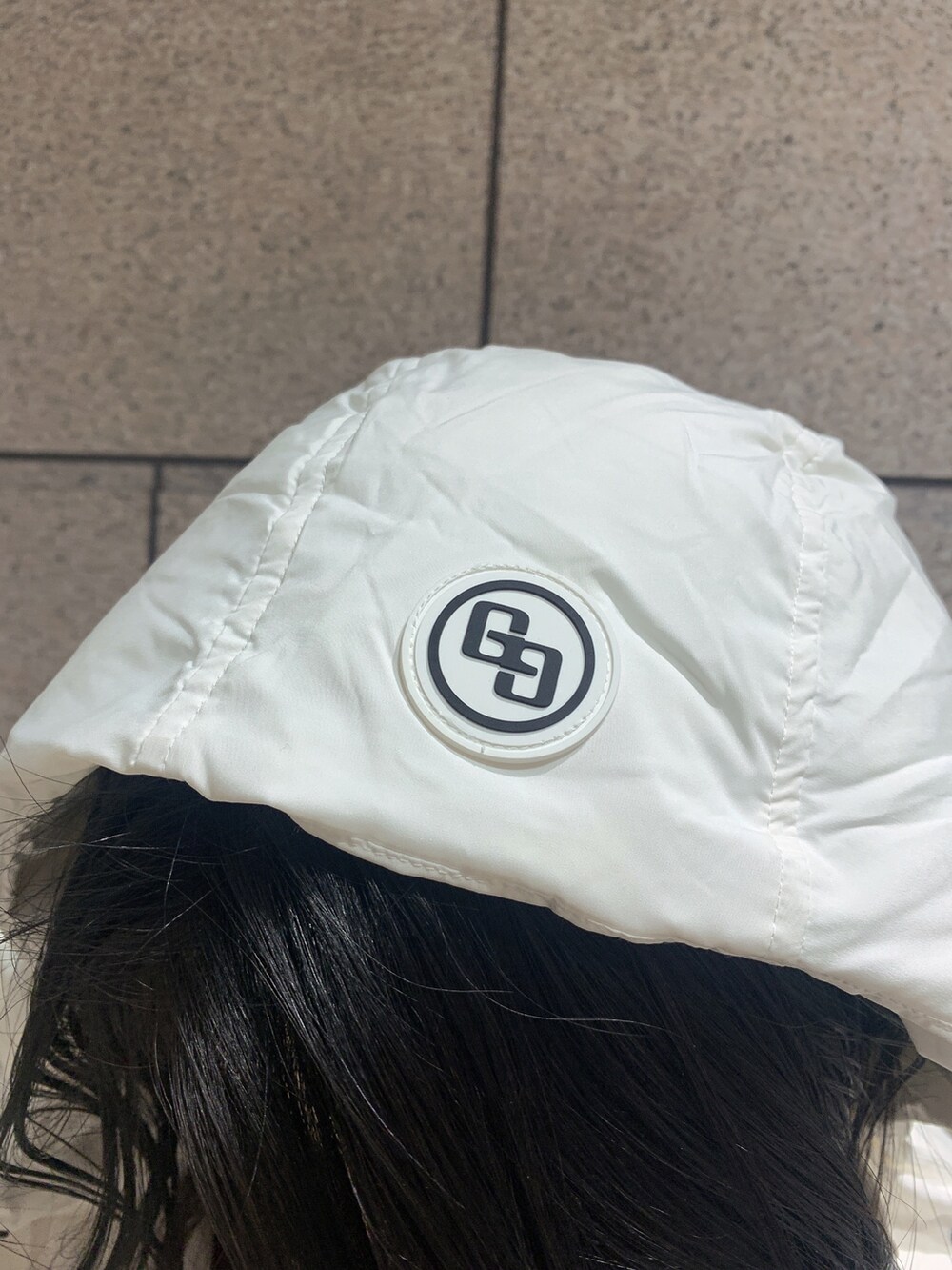 ブラック系のバックパック/リュック、ブラック系のブーツ、ホワイト系のダウンジャケット/コートを着用したレディースの冬コーディネートの7枚目の写真