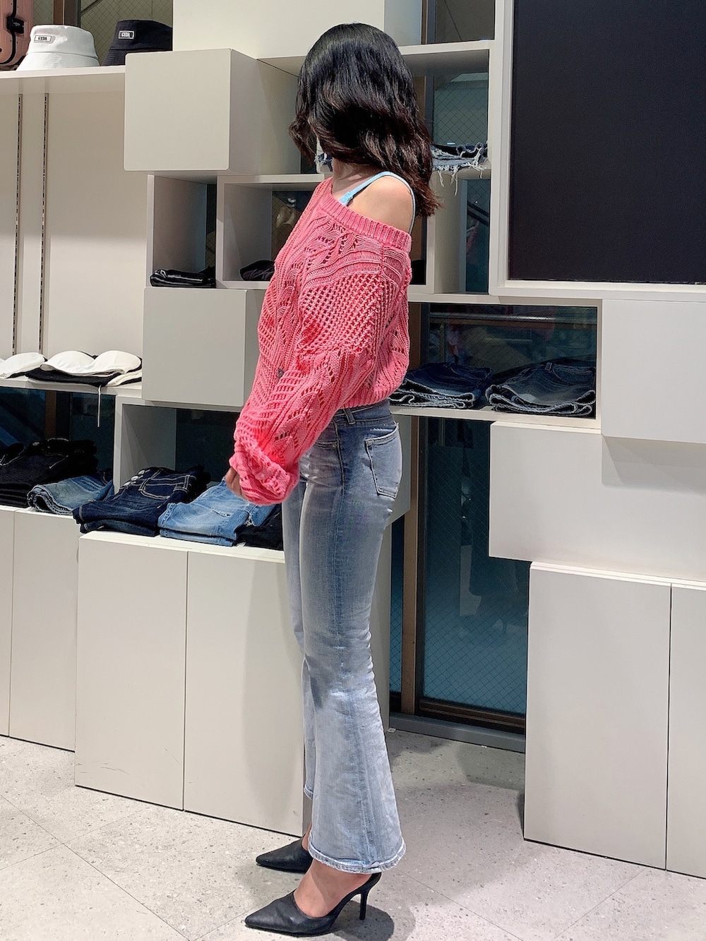 ブルー系のデニムパンツ、ブラック系のパンプス、ピンク系のカーディガン/ボレロを着用したレディースの春コーディネートの2枚目の写真