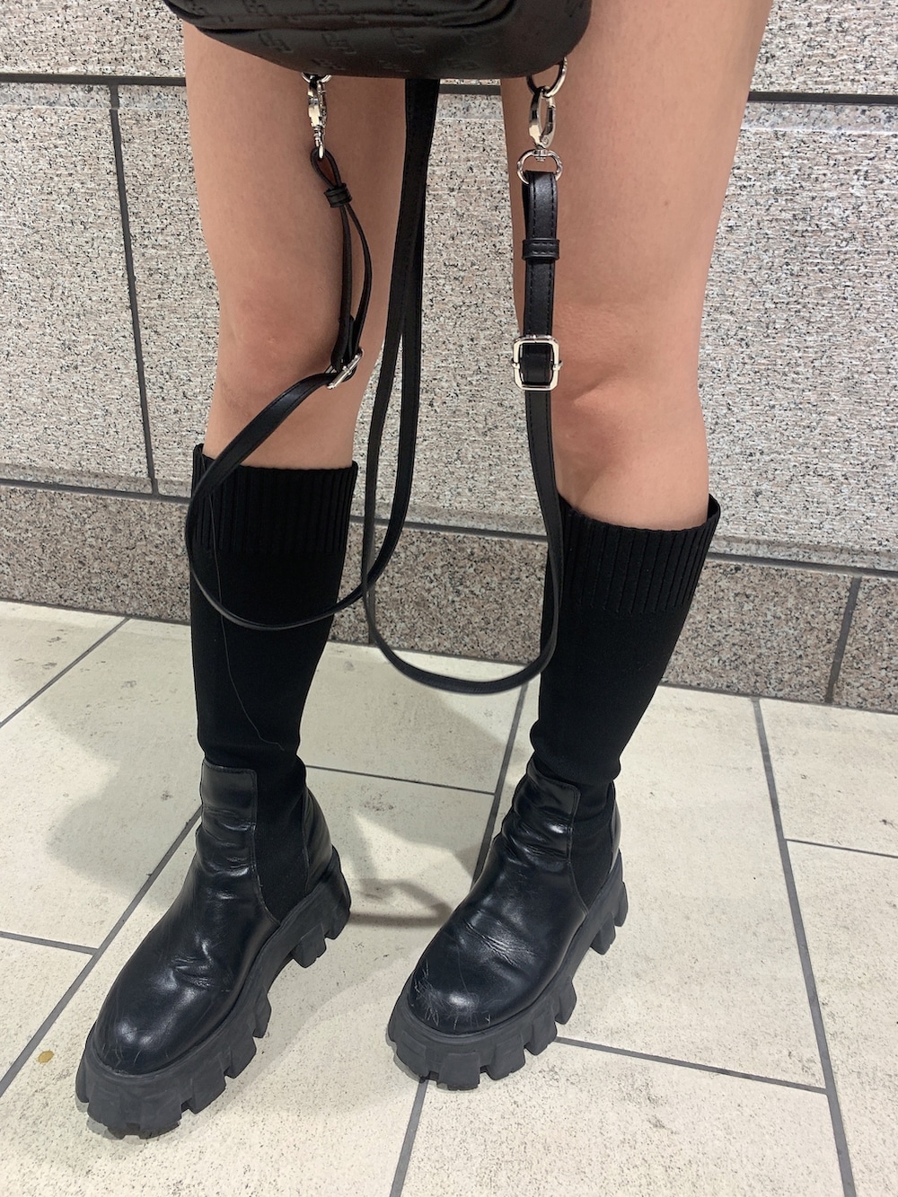 ベージュ系のワンピース、ブラック系のブーツ、ブラック系のバックパック/リュックを着用したレディースの冬コーディネートの5枚目の写真