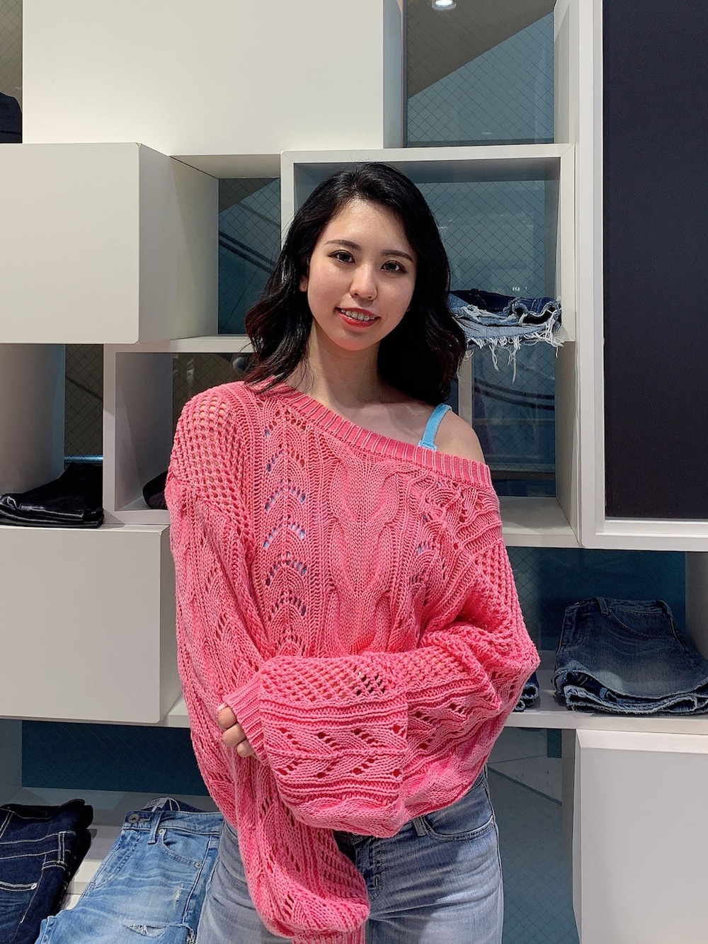 ブルー系のデニムパンツ、ブラック系のパンプス、ピンク系のカーディガン/ボレロを着用したレディースの春コーディネートの4枚目の写真