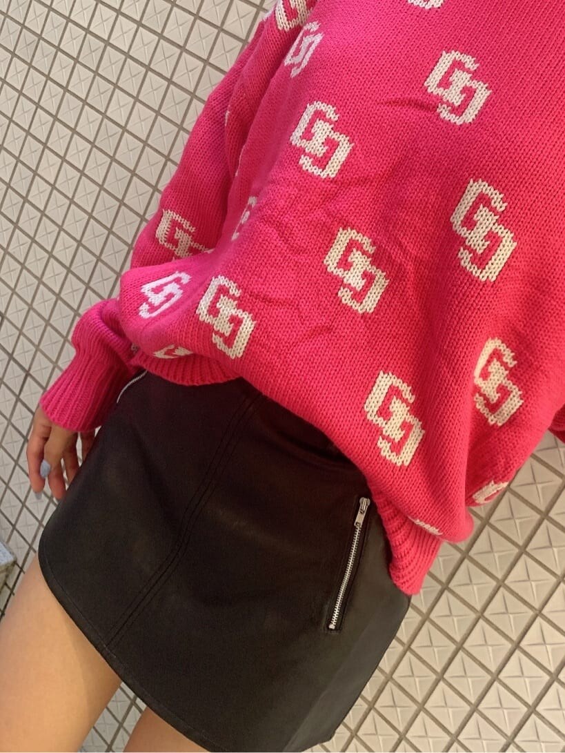 ピンク系のニット/セーター、ブラック系のスカート、ブラック系のブーツを着用したレディースの秋コーディネートの6枚目の写真