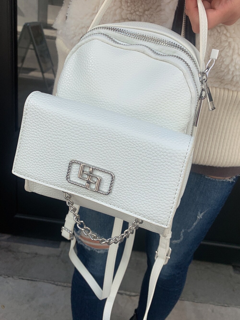 ブルー系のデニムパンツ、ブラック系のブーツ、ホワイト系のバックパック/リュックを着用したレディースの冬コーディネートの9枚目の写真