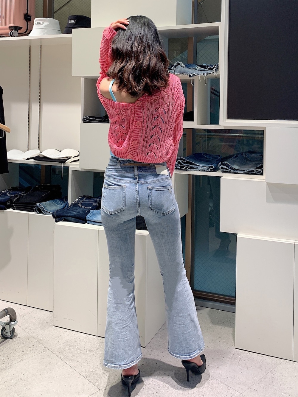 ブルー系のデニムパンツ、ブラック系のパンプス、ピンク系のカーディガン/ボレロを着用したレディースの春コーディネートの3枚目の写真