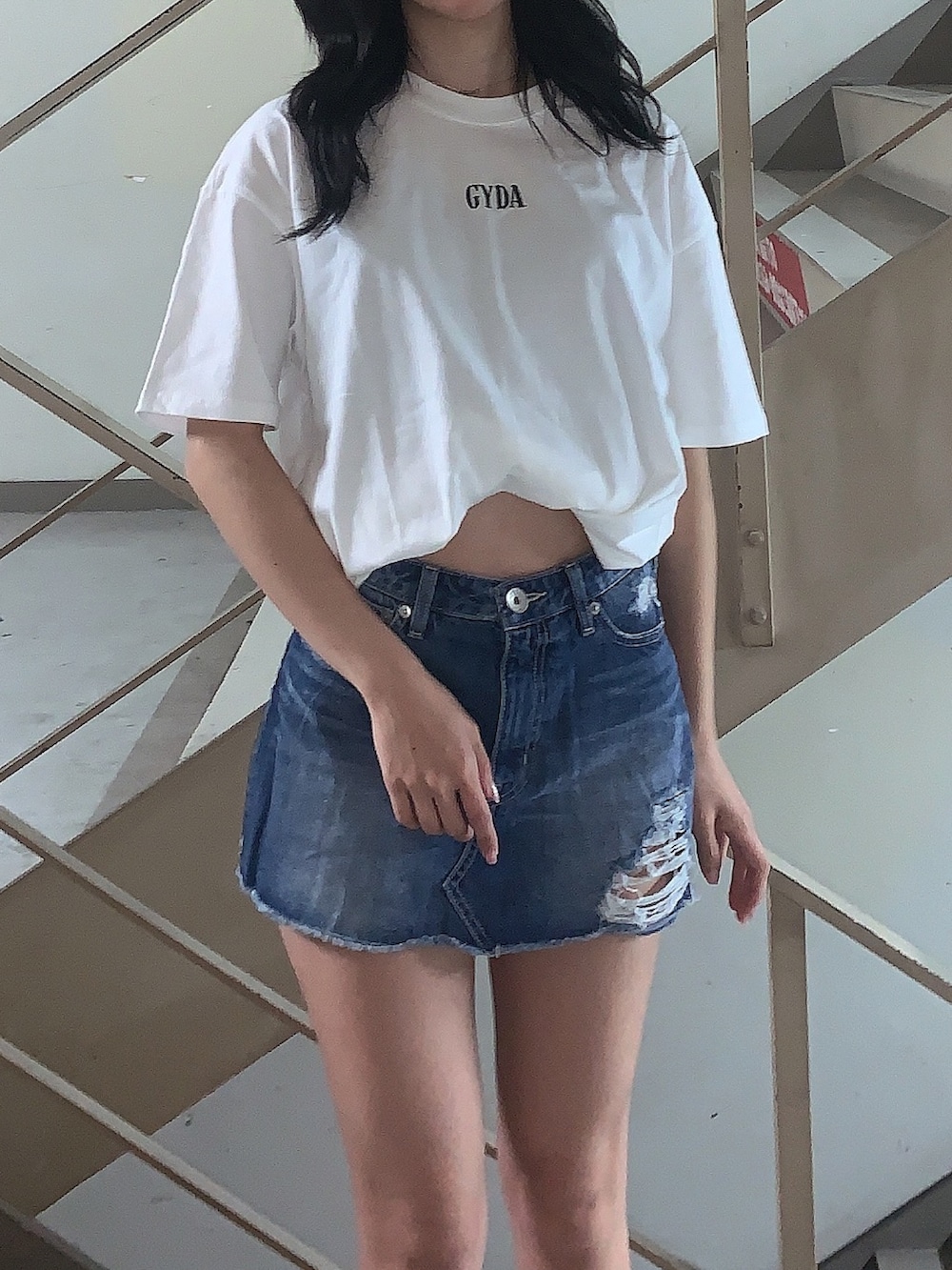 ブルー系のデニムスカート、ホワイト系のサンダル、ホワイト系のTシャツ/カットソーを着用したレディースの春コーディネートの4枚目の写真