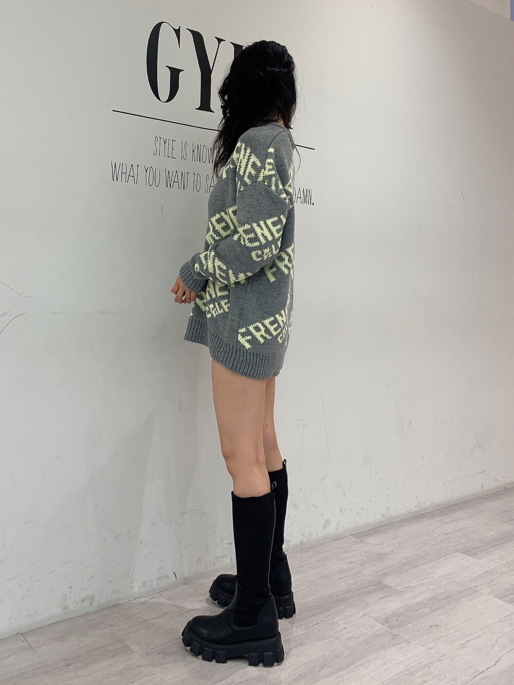 ブラック系のブーツ、ブラック系のデニムパンツ、グレー系のニット/セーターを着用したレディースの秋コーディネートの2枚目の写真