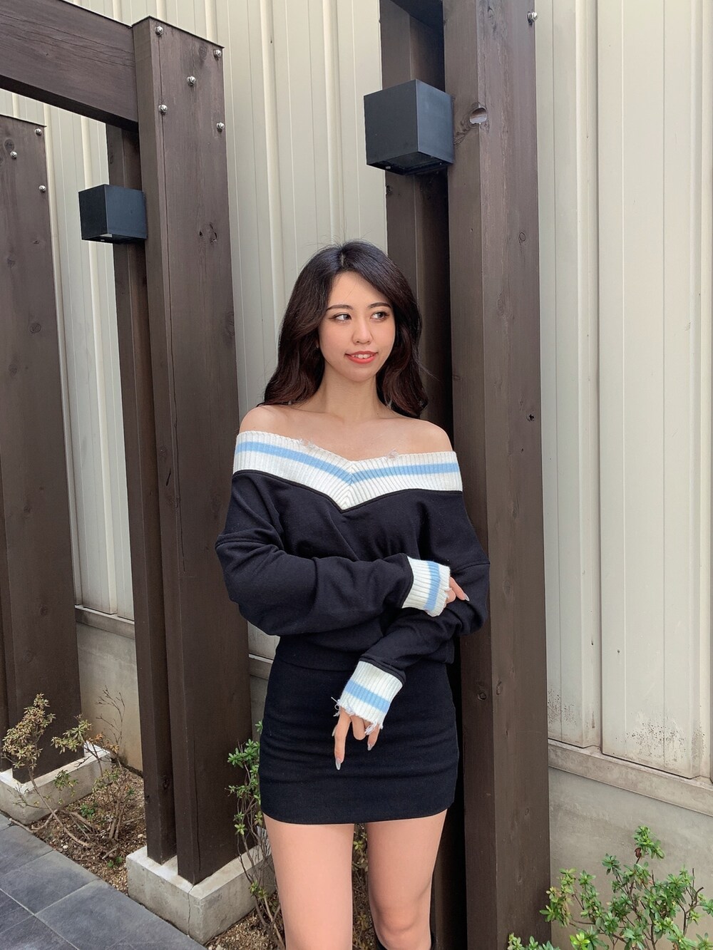 ブラック系のワンピース、ブラック系のブーツを着用したレディースの春コーディネートの4枚目の写真