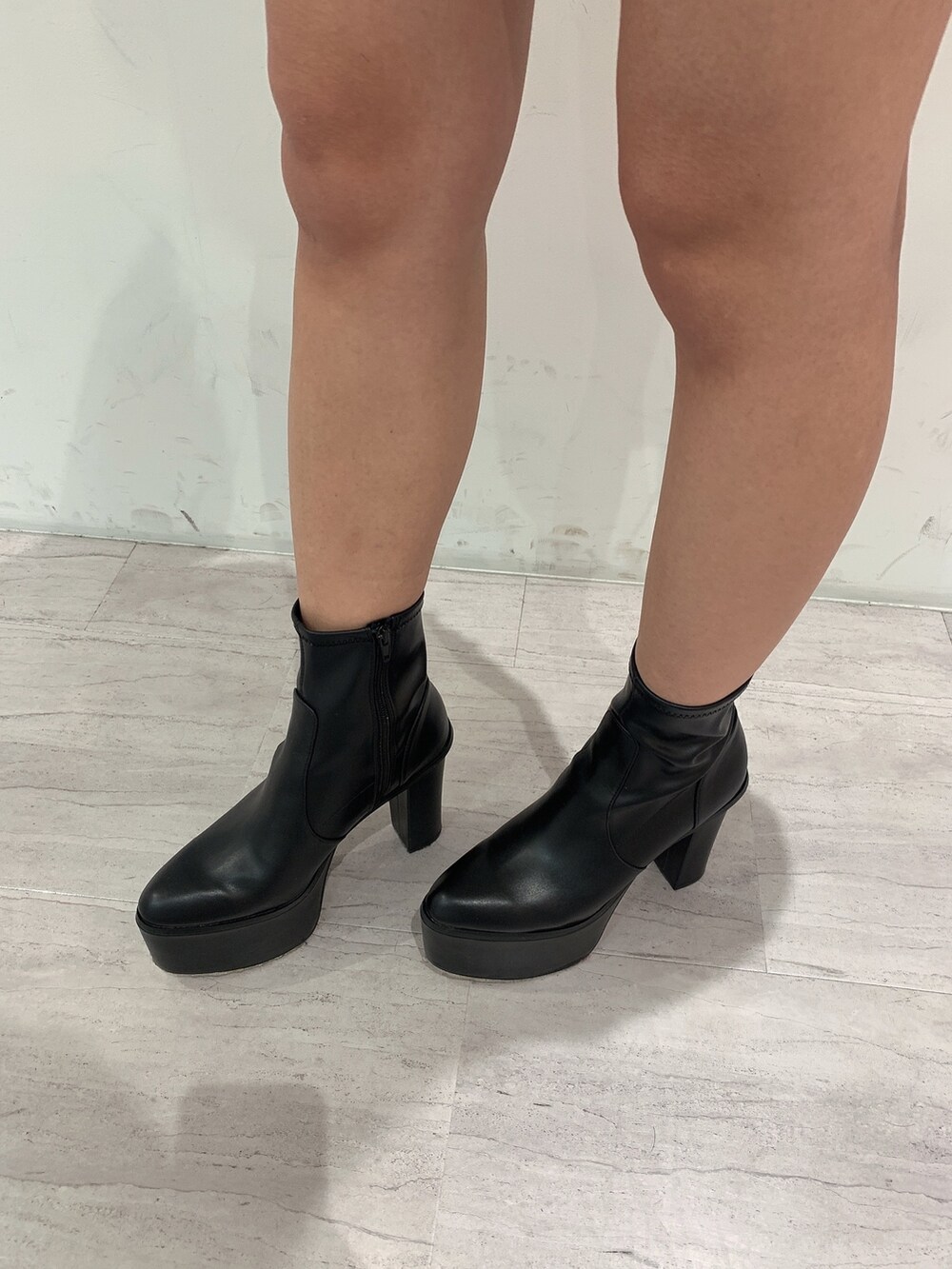 ブルー系のスカート、ブラック系のブーツ、ホワイト系のニット/セーターを着用したレディースの冬コーディネートの9枚目の写真