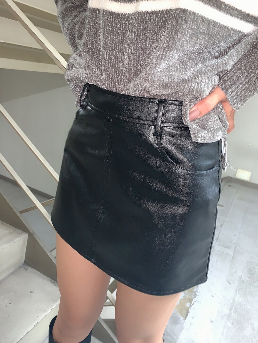 グレー系のニット/セーター、ブラック系のスカート、ブラック系のブーツを着用したレディースの秋コーディネートの6枚目の写真