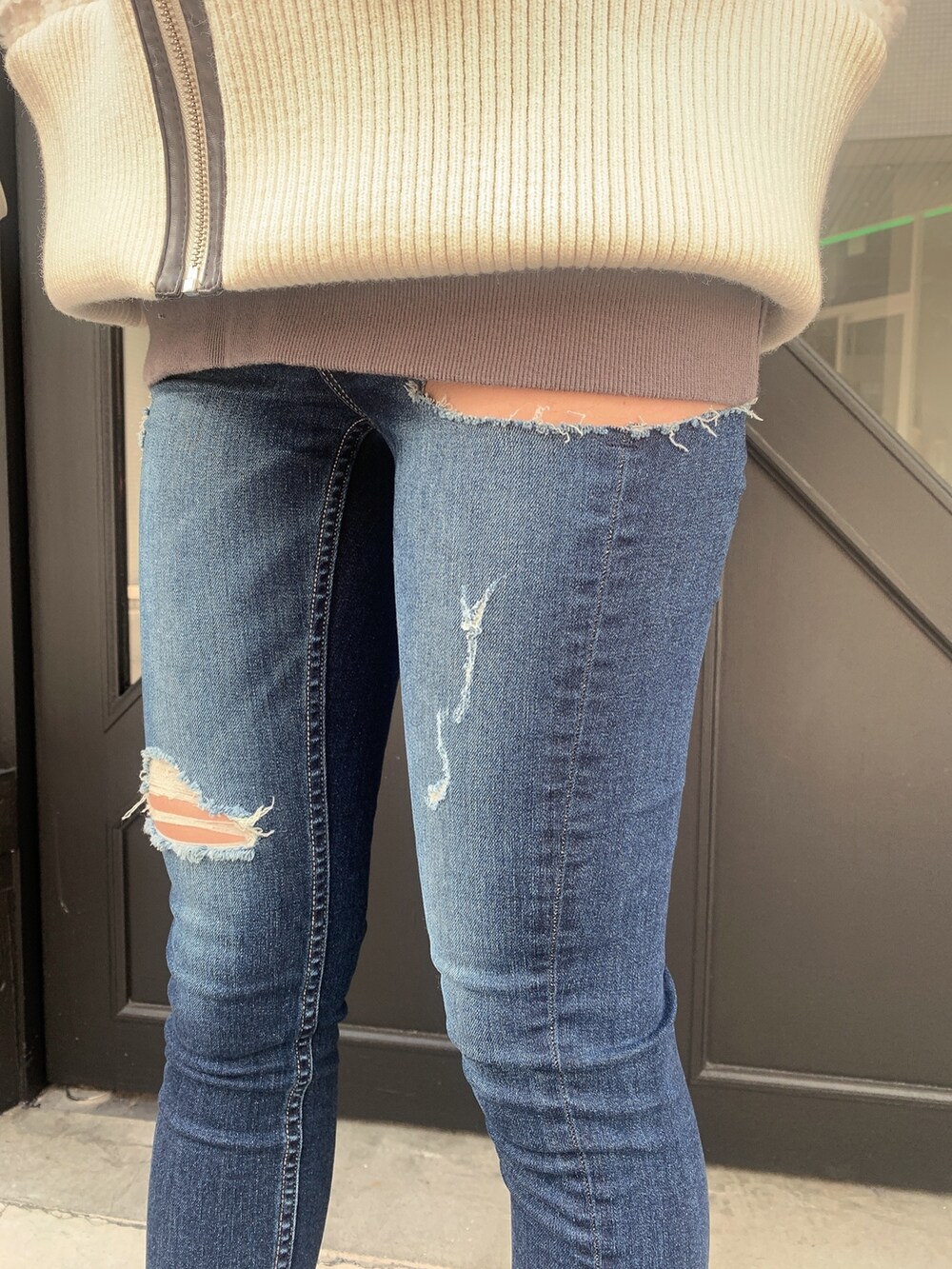 ブルー系のデニムパンツ、ブラック系のブーツ、ホワイト系のバックパック/リュックを着用したレディースの冬コーディネートの8枚目の写真