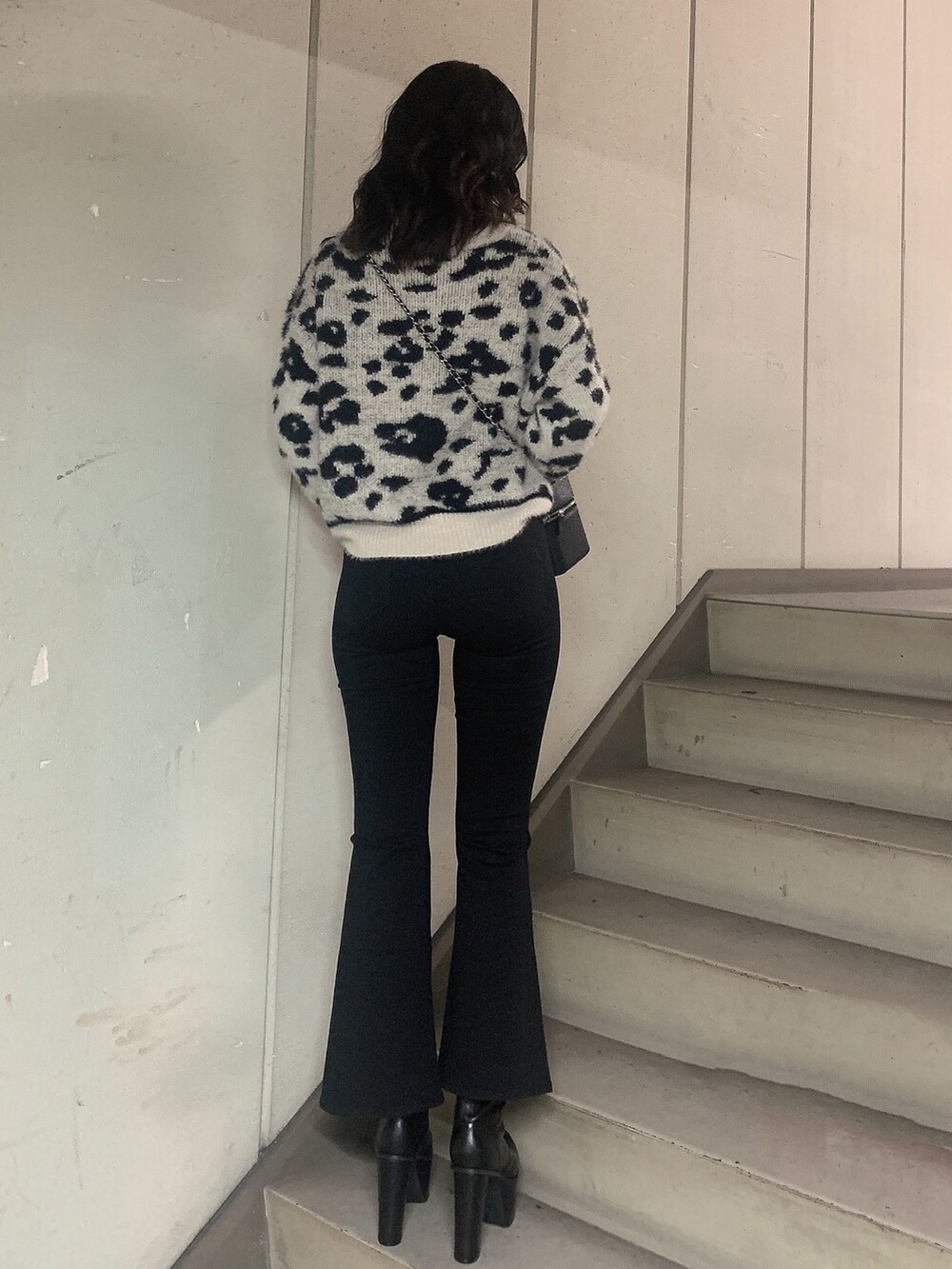 ブラック系のブーツ、ブラック系のデニムパンツ、ホワイト系のニット/セーターを着用したレディースの冬コーディネートの3枚目の写真