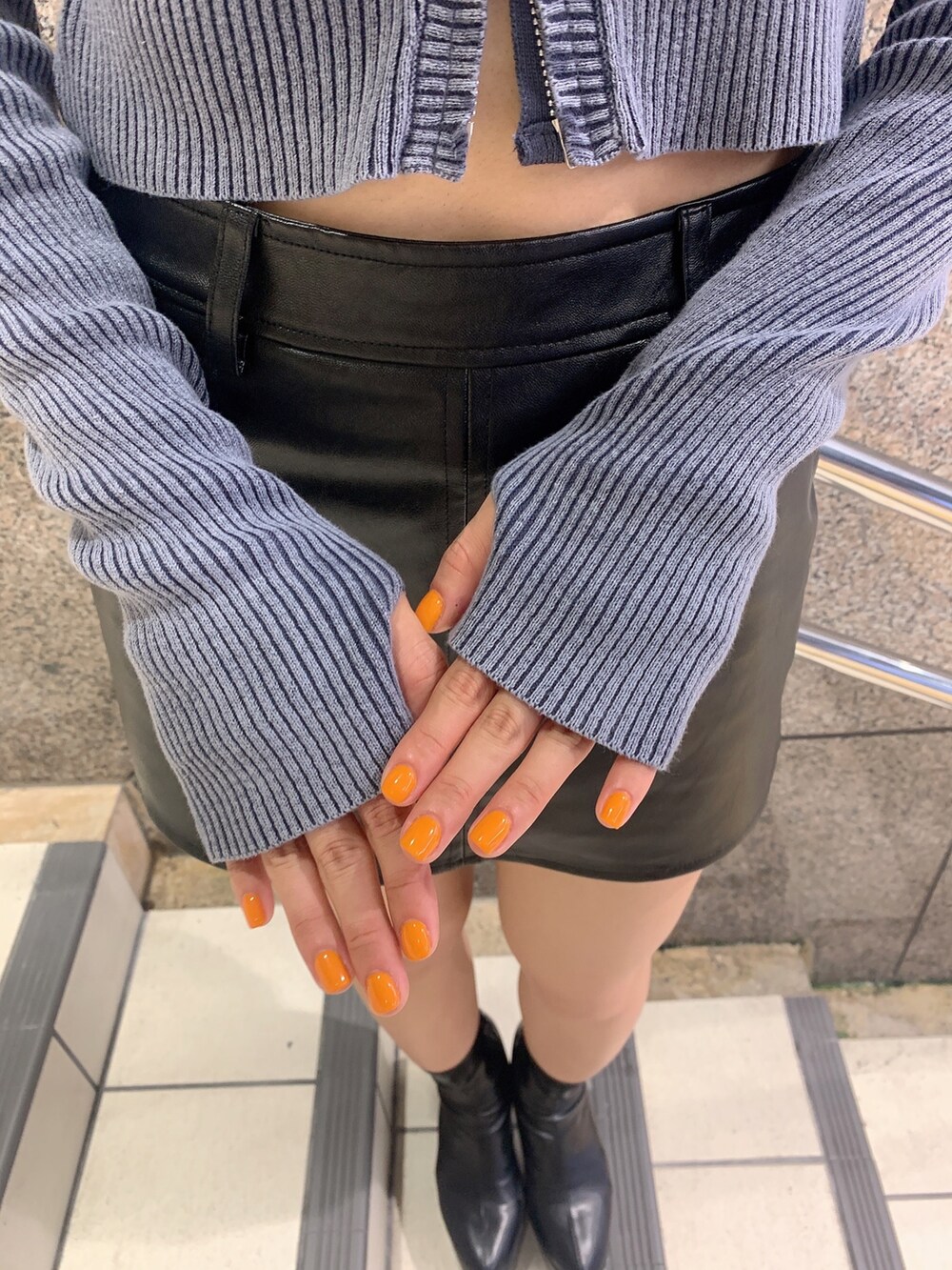 ブラック系のスカート、ブルー系のニット/セーター、ブラック系のブーツを着用したレディースの秋コーディネートの7枚目の写真