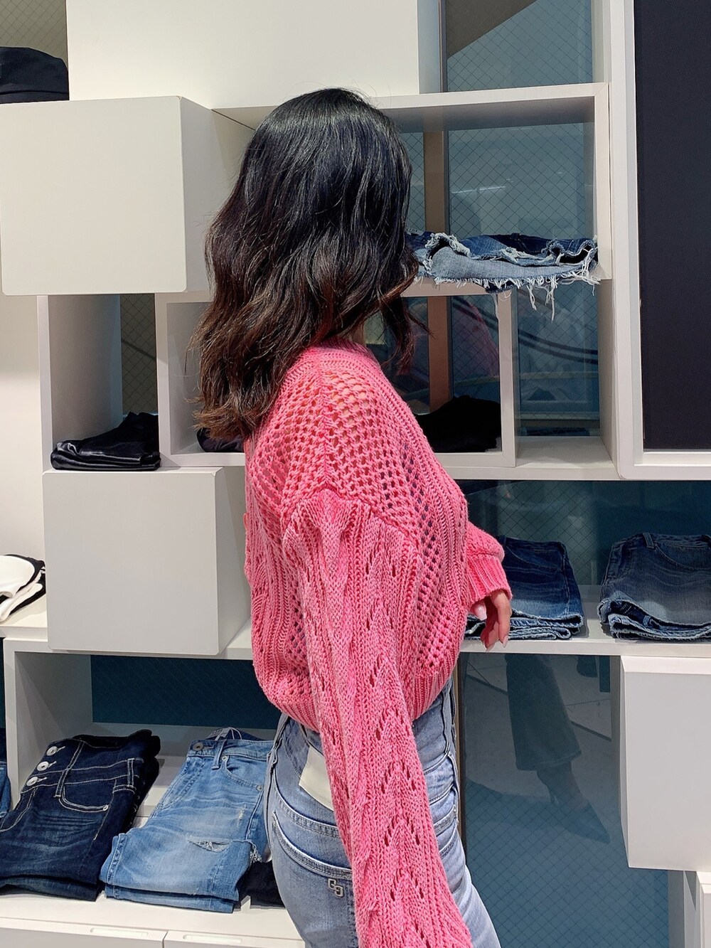 ブルー系のデニムパンツ、ブラック系のパンプス、ピンク系のカーディガン/ボレロを着用したレディースの春コーディネートの6枚目の写真