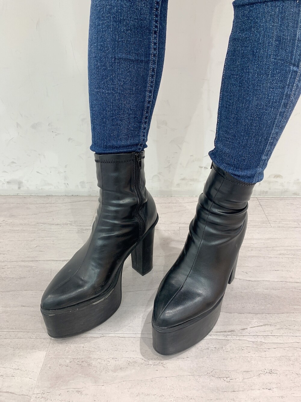 ブルー系のデニムパンツ、ブラック系のブーツ、ブラック系のニット/セーターを着用したレディースの秋コーディネートの9枚目の写真