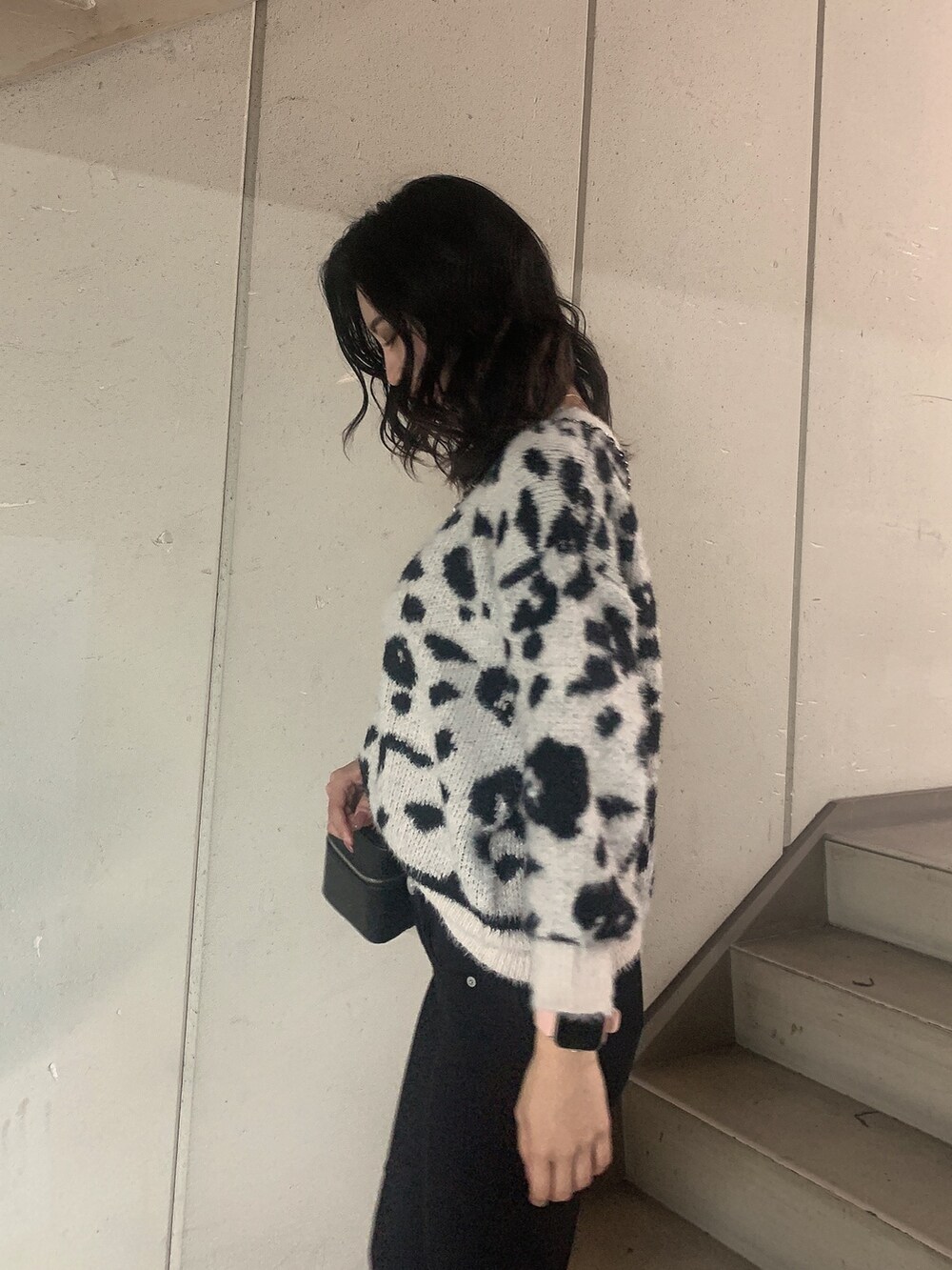 ブラック系のブーツ、ブラック系のデニムパンツ、ホワイト系のニット/セーターを着用したレディースの冬コーディネートの5枚目の写真