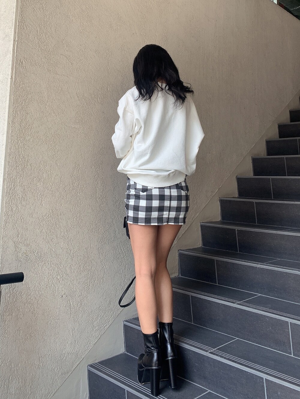 ホワイト系のスウェット、その他のスカート、ブラック系のブーツを着用したレディースの冬コーディネートの2枚目の写真