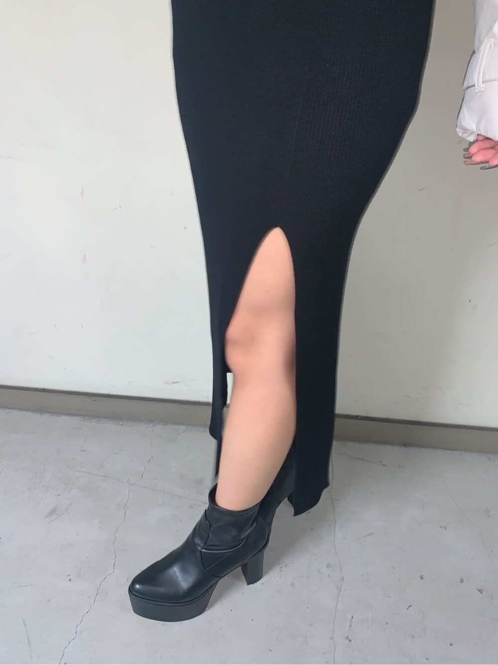 ブラック系のブーツ、ブラック系のニット/セーター、ブラック系のスカートを着用したレディースの秋コーディネートの6枚目の写真