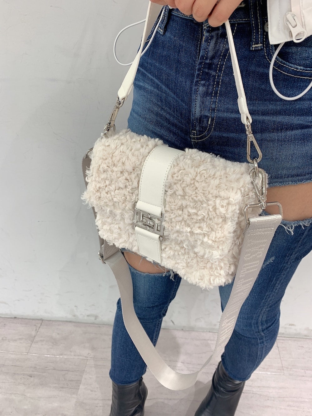 ブルー系のデニムパンツ、ブラック系のブーツ、ブラック系のニット/セーターを着用したレディースの秋コーディネートの8枚目の写真