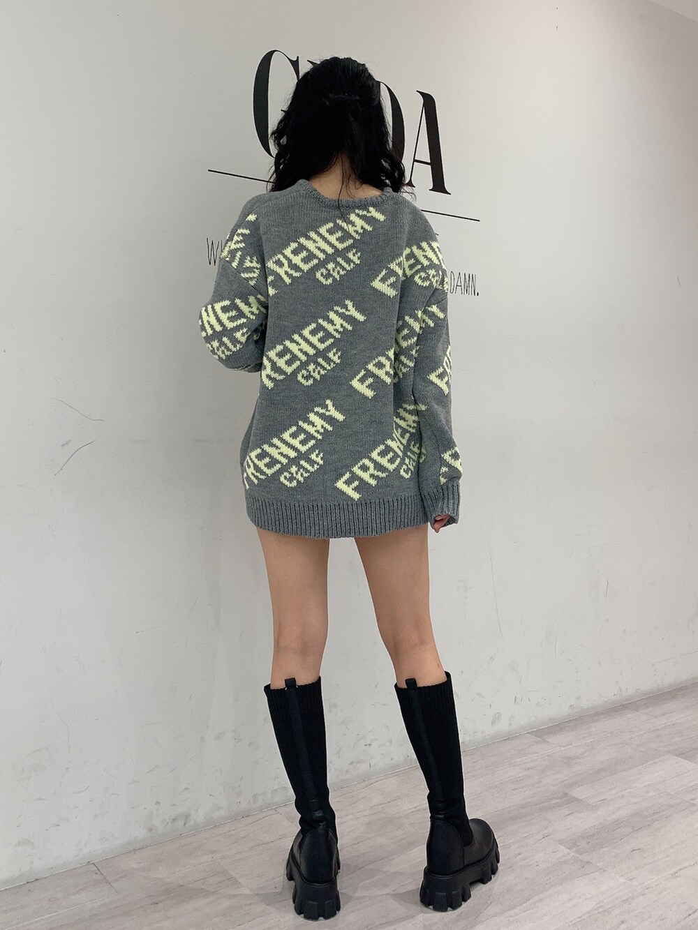 ブラック系のブーツ、ブラック系のデニムパンツ、グレー系のニット/セーターを着用したレディースの秋コーディネートの3枚目の写真
