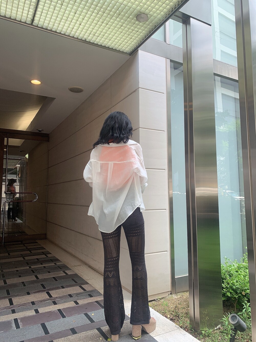 ホワイト系のサンダル、グレー系のその他パンツ、オレンジ系のニット/セーターを着用したレディースの春コーディネートの2枚目の写真