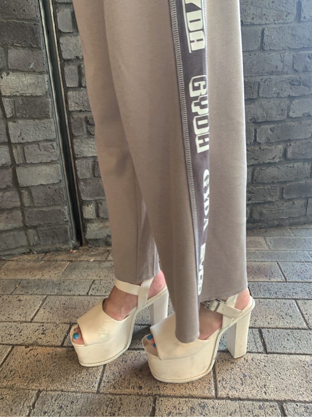 ベージュ系のその他パンツ、ホワイト系のサンダル、ベージュ系のパーカーを着用したレディースの夏コーディネートの7枚目の写真