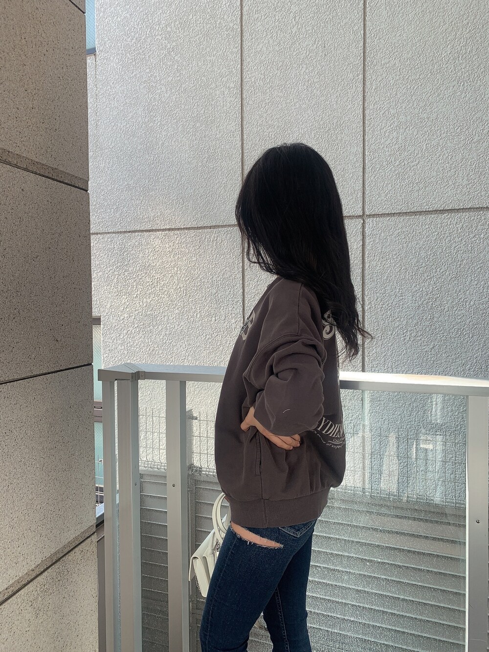 ブラック系のブーツ、ブルー系のデニムパンツ、ホワイト系のバックパック/リュックを着用したレディースの冬コーディネートの7枚目の写真