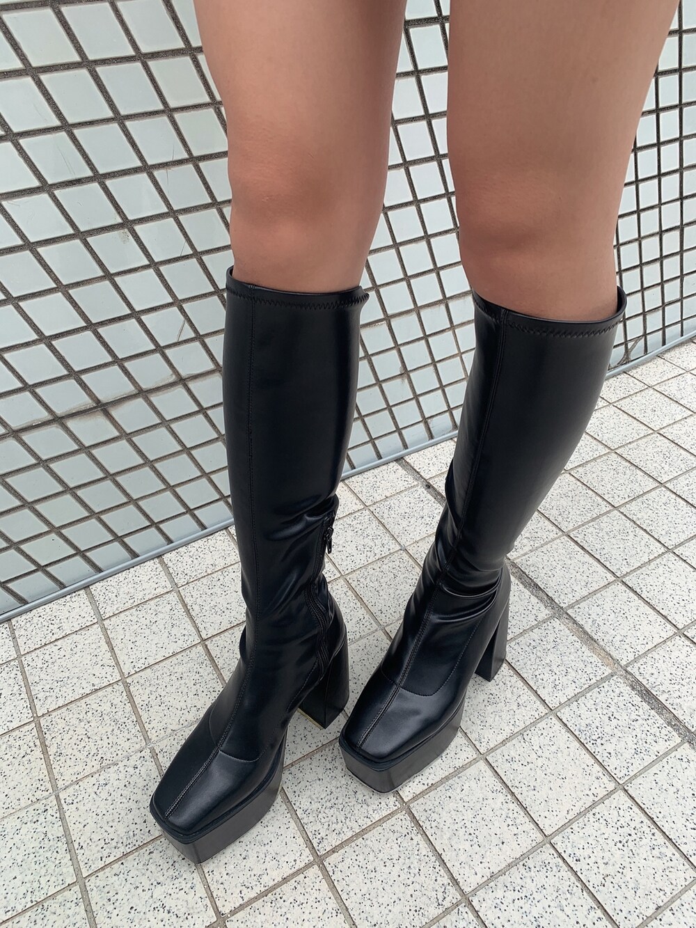 ブルー系のデニムスカート、ブラック系のブーツ、ホワイト系のニット/セーターを着用したレディースの秋コーディネートの8枚目の写真