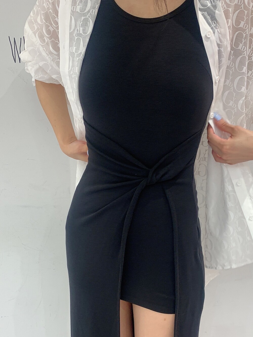 ブラック系のサンダル、ブラック系のワンピース、ホワイト系のシャツ/ブラウスを着用したレディースの夏コーディネートの6枚目の写真