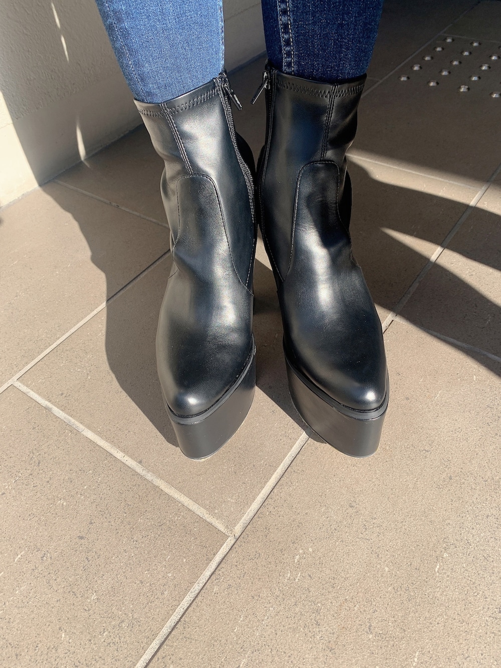 ブラック系のブーツ、ブルー系のデニムパンツ、ブラック系のニット/セーターを着用したレディースの冬コーディネートの7枚目の写真