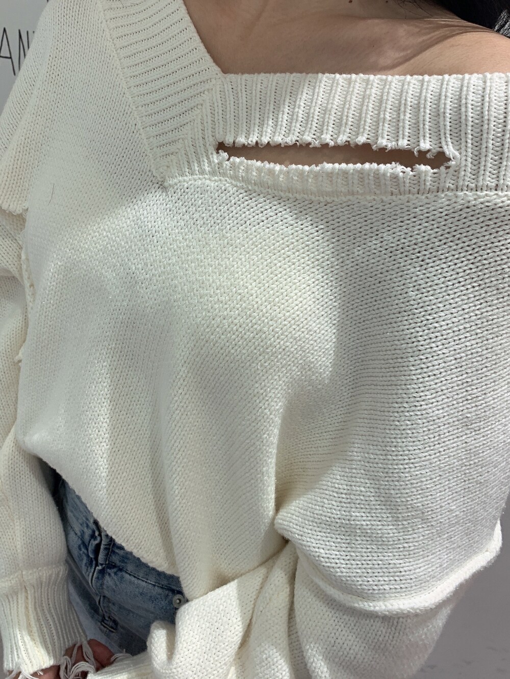 ブルー系のスカート、ブラック系のブーツ、ホワイト系のニット/セーターを着用したレディースの冬コーディネートの6枚目の写真