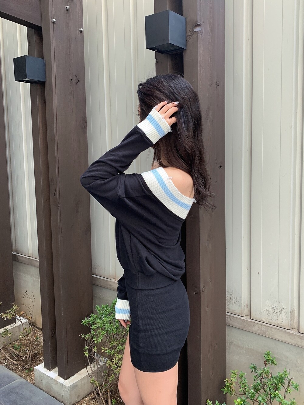 ブラック系のワンピース、ブラック系のブーツを着用したレディースの春コーディネートの6枚目の写真