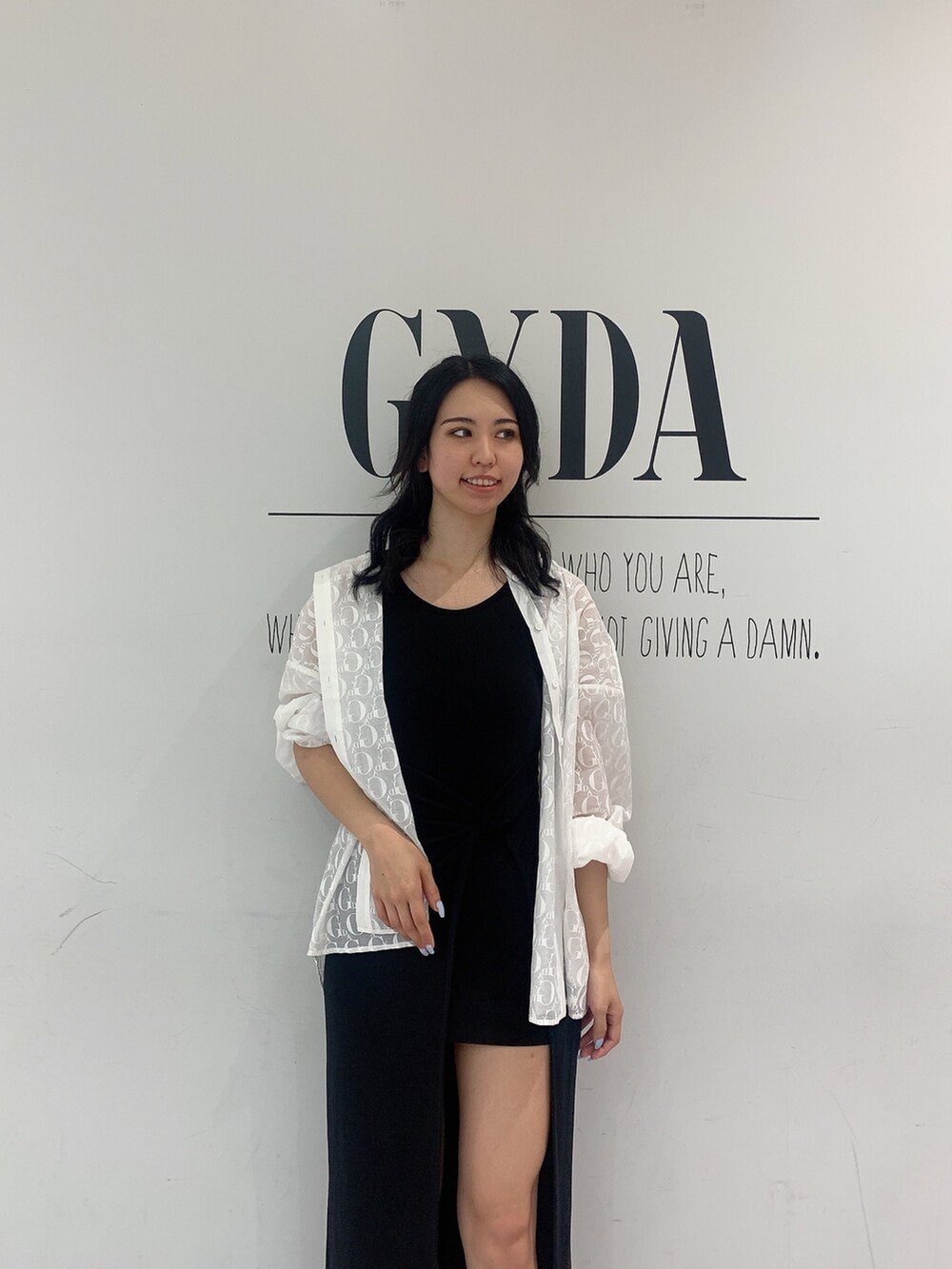 ブラック系のサンダル、ブラック系のワンピース、ホワイト系のシャツ/ブラウスを着用したレディースの夏コーディネートの3枚目の写真