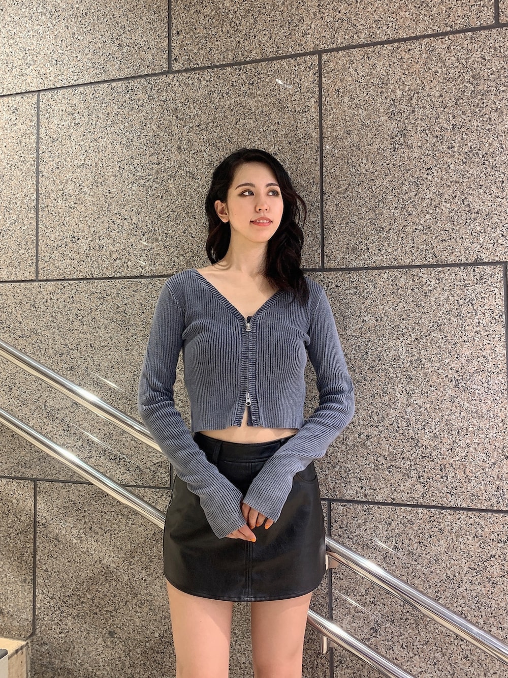 ブラック系のスカート、ブルー系のニット/セーター、ブラック系のブーツを着用したレディースの秋コーディネートの4枚目の写真